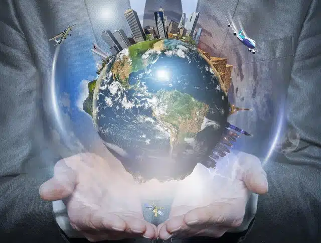 Planet earth in human hands on blue background